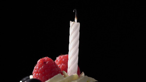 在庆祝生日蛋糕时点燃蜡烛用黑色背景吹散的11秒视频