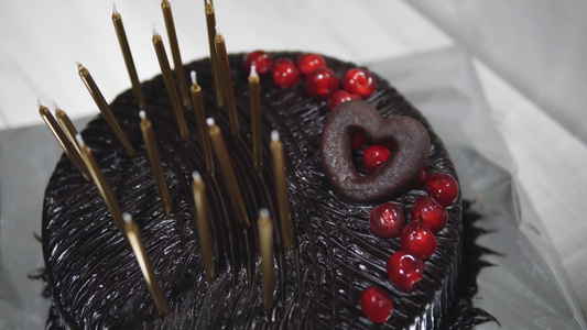 巧克力生日蛋糕上面有蜡烛在节日餐桌上视频