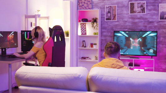 一对夫妇在有彩色灯光的房间里玩网上电子游戏视频