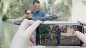 在瀑布附近用手机拍情侣相片19秒视频