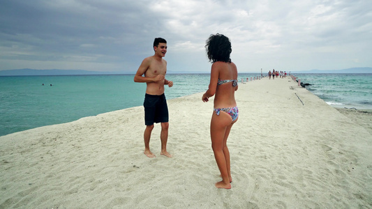 年轻情侣在沙滩上玩得开心视频