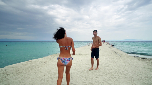 年轻情侣在沙滩上玩得开心视频