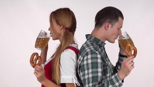 性感的巴伐利亚女人和她的男人用椒盐脆饼享用啤酒视频
