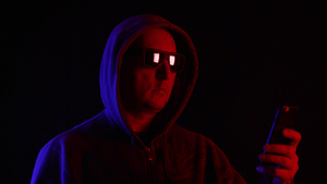 男人在太阳镜和兜帽时在黑暗中使用智能手机17秒视频
