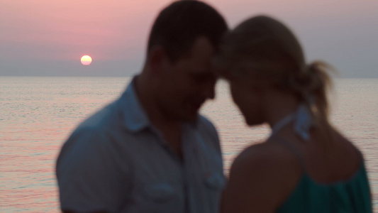 日落时在海滩上相爱的情侣视频