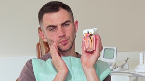 年轻男子牙痛坐在诊所的牙科椅上8秒视频