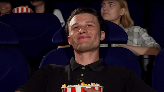 快乐的有魅力的男人微笑在电影院的相机视频