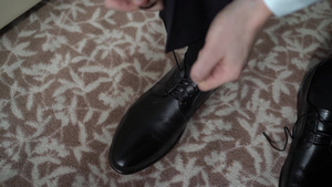 青年男子穿上鞋子为庆祝活动商业会议或婚礼穿衣14秒视频