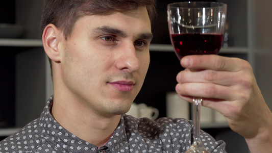 英俊男人闻着美味的红酒在家里放松视频
