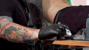 纹身艺术家拿纹身机器在他的工作室工作12秒视频