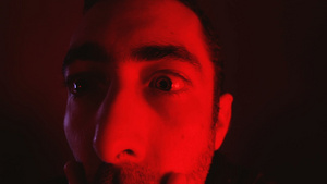 红色恐怖光效下面部表情震惊的男子14秒视频