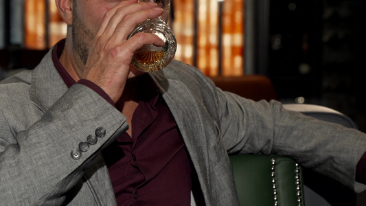 英俊的成熟男子在喝威士忌时对相机微笑视频