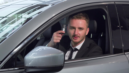 开着汽车钥匙坐在经销商的一辆新汽车上生意人很兴旺车视频