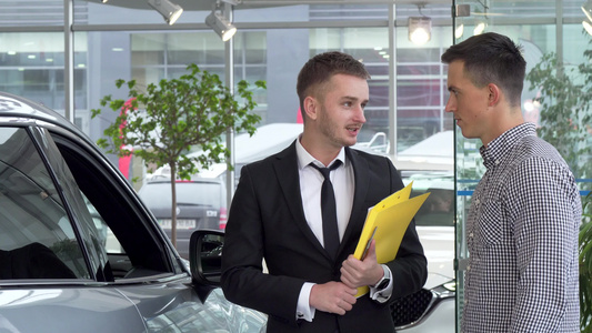 帮助其男性客户选择汽车买车的友好汽车经销商视频