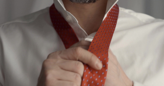 男人穿衣服打扮调整领带在家中的脖子上视频