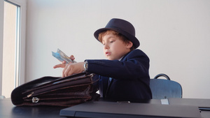 小男孩看起来像企业家把钱藏在公文包里笑声21秒视频