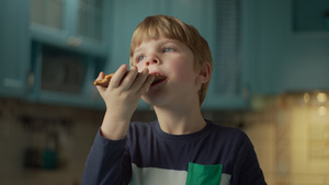 金发学龄前男孩的肖像喜欢吃巧克力棒站在蓝色的厨房孩子31秒视频