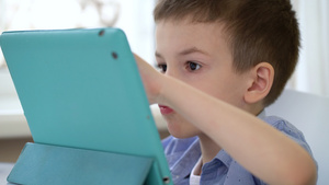 学龄前儿童坐在一张桌子上看一张数字平板电脑12秒视频