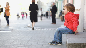 独自坐在街上的小男孩人们路过马路12秒视频