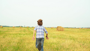 在乡村的秋天田里跑掉的少年背着大草原景色看到少年在18秒视频