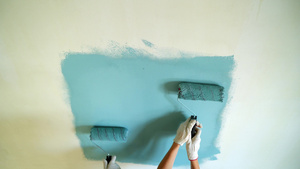 两名女工在公寓或房屋中用滚滚机油漆墙壁9秒视频