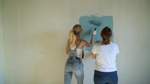 两名女工在公寓用油漆滚筒刷墙8秒视频