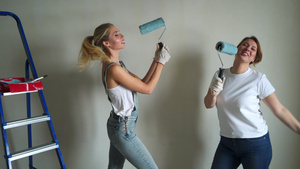 两名女工在公寓用油漆滚筒刷墙10秒视频