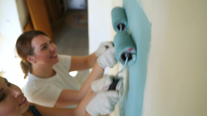 两名女工在公寓用油漆滚筒刷墙7秒视频