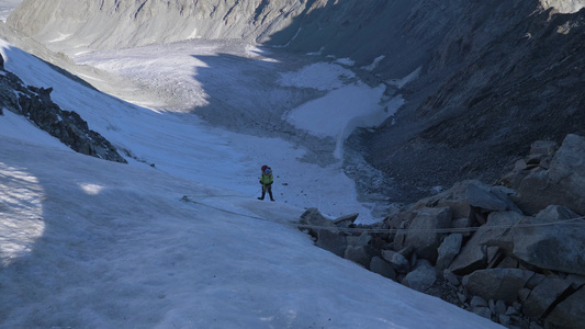 山人穿长裤在陡峭的山口上用固定绳索攀升慢动作视频