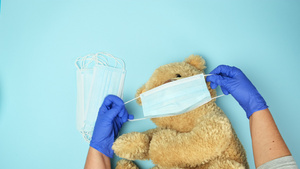 蓝粉红色背景防呼吸道疾病概念的医学面罩中的大泰迪熊16秒视频