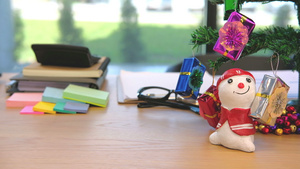 在工作场所的办公桌上装饰礼品箱雪人并装饰圣诞树16秒视频