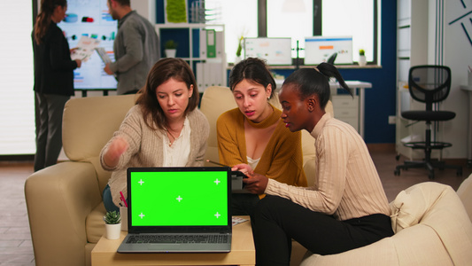 女商人在笔记本电脑后面用绿屏进行讨论视频