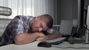 完成工作后男人在桌子上睡觉12秒视频