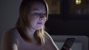 年轻女子在晚上睡觉前在床上使用手机移动成瘾者的概念6秒视频