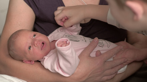 有新生儿的奶奶和弟弟抚摸婴儿手的哥哥13秒视频