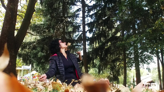 秋天全家欢乐的抛掷叶子赤脚坐在公园里视频