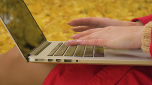 穿红色斗篷的年轻caucasian女子在笔记本电脑15秒视频