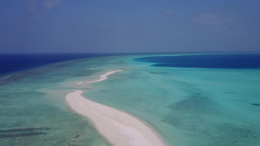 蓝色环礁湖和白色沙滩背景的美丽海岸海滩旅行空中观察视频