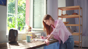 年轻女子在厨房写笔记31秒视频