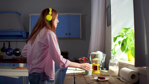 女孩用耳机跳舞和喝茶早上回家44秒视频