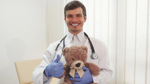 快乐的医生拿着泰迪熊大拇指7秒视频