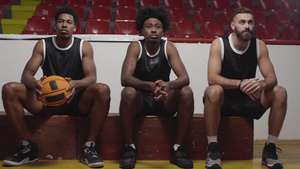 三个篮球运动员坐在一个板凳上观看比赛11秒视频