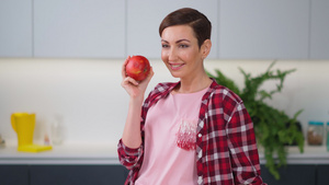 闻着新鲜的苹果手里拿着它穿着格子衬衫留着短发型一边15秒视频