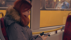 坐在电车上的红发妇女使用智能手机上网9秒视频
