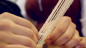 用传统织机编织的女人手的特写镜头家用织机传统复古编织6秒视频