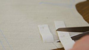 裁缝剪裁切一条窄条织物10秒视频