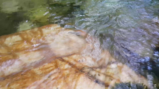 紧闭地看见水流的流光水从石头之间掉落而出流入石块之间视频