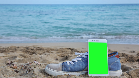 海滩上有绿色屏幕的电话视频
