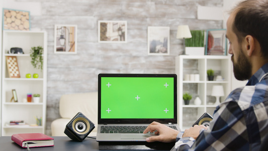 缩放在男子用绿色屏幕看笔记本电脑的镜头中视频