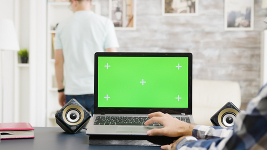 男人用绿色屏幕在笔记本电脑上触摸板滚动视频